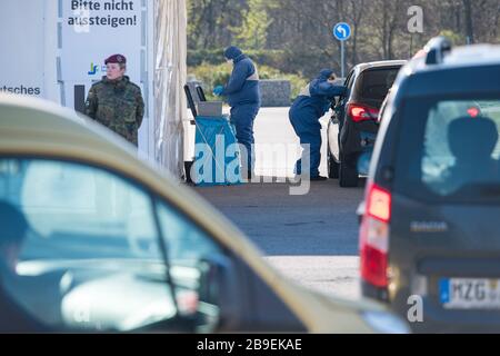 24. März 2020, Saarland, Saarlouis: Zwei Ärzte nehmen in einer Einfahrteststation auf dem Parkplatz der Ford-Werke in Saarlouis Tupfer. Am Morgen wurden die ersten Einfahrstationen im Saarland in Betrieb genommen, in denen Tests für das Corona-Virus durchgeführt werden. Foto: Oliver Dietze / dpa Stockfoto