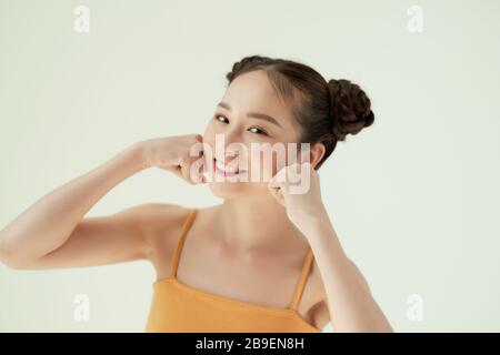 Portrait eines hübschen, hübschen Mädchens mit zwei Brötchen, die auf hellem Hintergrund isoliert sind Stockfoto