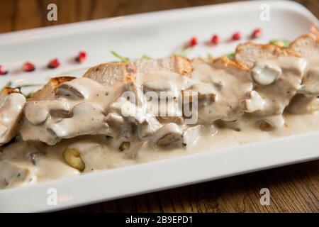 Huhn auf geriebenem Gnocchi in Sahnesauce aus Pilzen und Räucherkäse auf dem Tisch Stockfoto