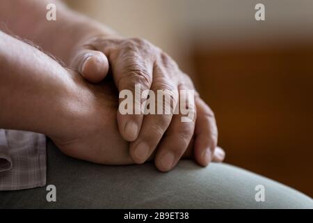 Nah oben gefaltete, zerknitterte männliche Hände, einsamer reifer Mann Stockfoto