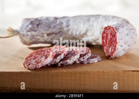 Köstliche Trockenwurst auf einem Holzschneidebrett in Scheiben Stockfoto