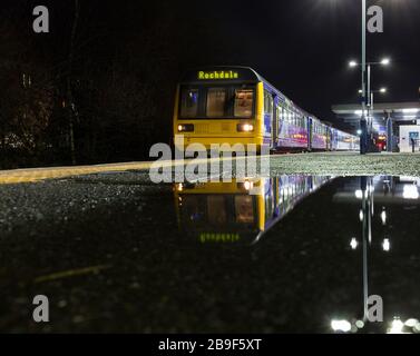 Der 142-Stufen-Zug der Northern Rail am Bahnhof Blackburn spiegelte sich in einer Pfütze auf dem Bahnsteig wider Stockfoto