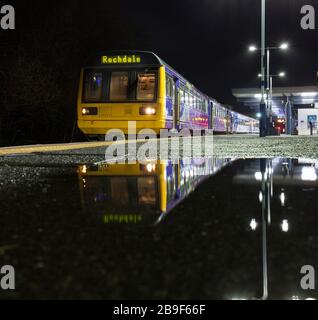 Der 142-Stufen-Zug der Northern Rail am Bahnhof Blackburn spiegelte sich in einer Pfütze auf dem Bahnsteig wider Stockfoto