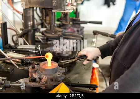 Glasflaschenfabrik - Maschinenblasen von geschmolzenem Glas Stockfoto