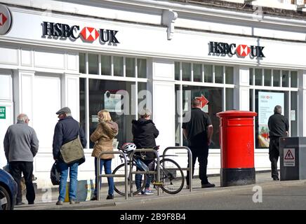Maidstone, Kent, Großbritannien. März 2020. Menschen zeigen soziale Distanz, während sie außerhalb der HSBC Bank Schlange stehen, bevor sie einzeln eingelassen werden Stockfoto