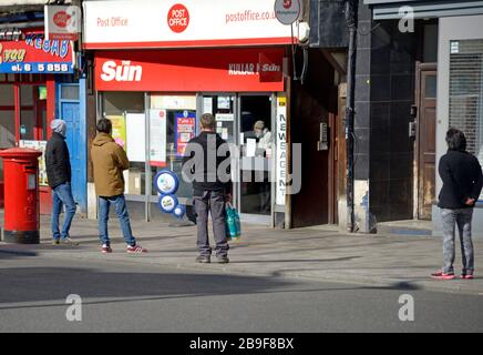 Maidstone, Kent, Großbritannien. März 2020. Menschen zeigen soziale Distanz, während sie vor einem Postamt Schlange stehen, bevor sie einzeln eingelassen werden Stockfoto