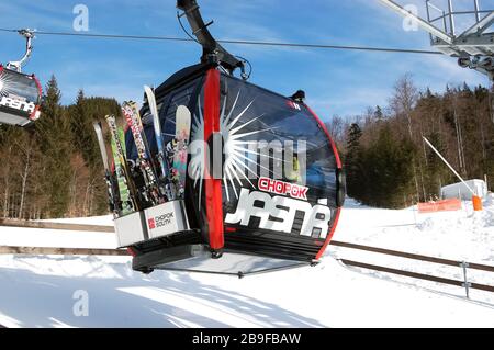 Jasna, Slowakei - 22. Januar 2019: An einem sonnigen Tag im Skigebiet nähert sich eine neue moderne Liftkabine der Station auf der Südseite des Chopok. Stockfoto