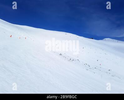 Jasna, Slowakei - 22. Januar 2019: Blauer Himmel, Luftseilbahn, Skifahrer und Panoramablick auf den Berghang in der Niederen Tatra an einem sonnigen Wintertag auf der Jas Stockfoto