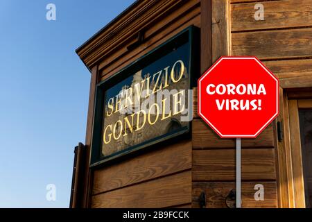 Blick auf die Holzbullierung der Servizio Gondole in Venedig mit einem Stoppschild, das Corona Virus sagt! Stockfoto