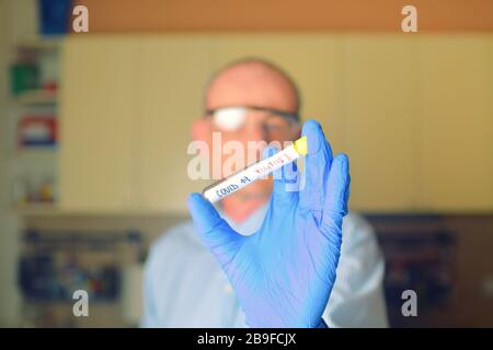 Doktor hält den COVID 19 Coronavirus Impfstoff in der Hand, infizierte Probe im Probenröhrchen, Impfstoff und Spritzenspritzenspritze, die er zur Vorbeugung verwendet, Immuni Stockfoto