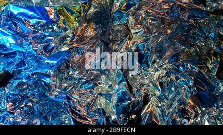 Dekorhintergrund aus zerknitterter Metallfolie, glänzende silberne Oberfläche. Schöne abstrakte Folientextur als Hintergrund für das Design. Nichteisenmetall. C Stockfoto
