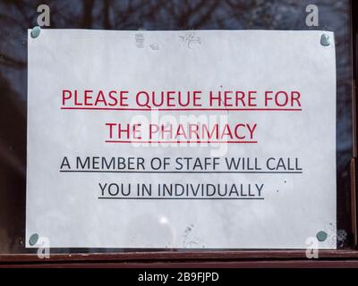 Willingham Cambridgeshire, Großbritannien. März 2020. Schilder in der Apotheke, um Mitarbeiter und Patienten vor Kreuzkontamination durch das Coronavirus zu schützen, die keine andere Wahl haben, als persönlich teilzunehmen. Heute Morgen nach der Nacht wurde den Menschen in ganz Großbritannien gesagt, dass sie zu Hause bleiben sollten, um die Verbreitung des Covid 19-Virus einzuschränken. Kredit: Julian Eales/Alamy Live News Stockfoto