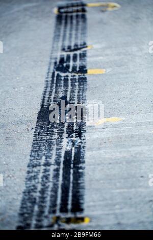 Schwarze Reifenspuren auf einer Betonstraße Stockfoto