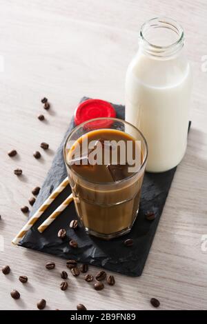 Eiskaffee oder Kaffe Latte in einem hohen Glas auf Holztisch Stockfoto