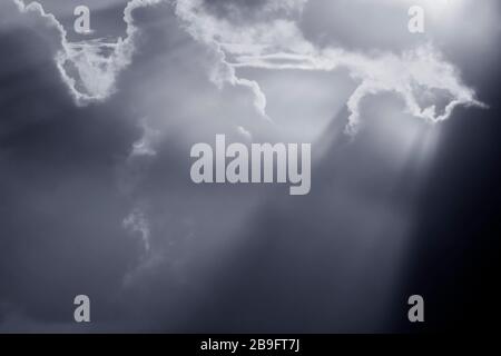 Wolkenscape mit Sonnenstrahlen. Verwendeter Infrarotfilter. Blau getönt. Stockfoto