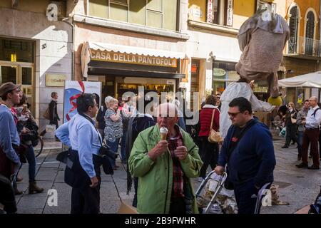 Ein Tourist isst ein Eis in einem geschäftigen Teil von Verona, Italien Stockfoto