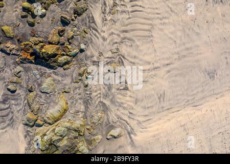 Luftbild eines leeren Gwithian-Strandes mit Wellen und Sanddünen an einem blauen Himmelstag Stockfoto