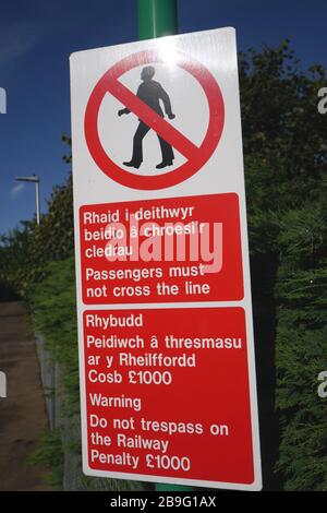 Ein zweisprachiges Schild in einem englischen und walisischen Warnfahrgast, das die Eisenbahnlinie Rhiwbina, Cardiff, Wales, Großbritannien nicht überqueren darf Stockfoto