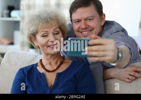 Mann mittleren Alters hält Smartphone Stockfoto