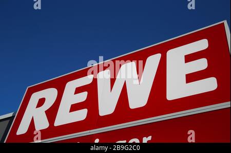 Heinsberg, Deutschland - 23. März. 2020: Nahaufnahme des isolierten Zeichens der deutschen Rewe-Supermarktkette gegen den klaren blauen Himmel Stockfoto