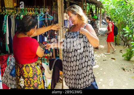 Ein weibliches Touristeneinkaufsbüro für Kleidung, Sanur Beach, Sanur, Bali, Indonesien. Stockfoto