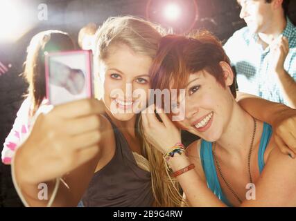 Fröhliche Teenager-Freundinnen, die selfie mit Smartphone auf Party nehmen Stockfoto