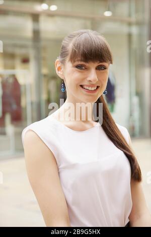 Portrait fröhliche junge Frau auf dem Bürgersteig Stockfoto