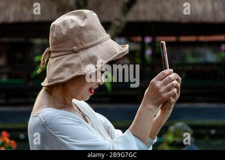 Ein Asiatischer Tourist, Der Fotos Auf Pura Taman Saraswati, Bali, Indonesien, Nimmt. Stockfoto