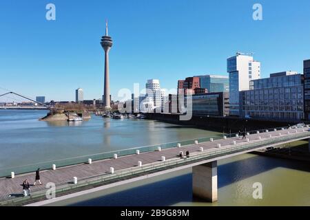 Düsseldorf, Deutschland. März 2020. firo: 24.03.2020, Deutschland, NRW, Düsseldorf, Drohnenfoto, Unternehmen, wenige Fußgänger im Medienhafen Düsseldorf, an der lebenden Brücke, Kontaktverbot, das Sammeln von mehr als zwei Personen ist aufgrund der Coronakrise verboten, Sperrung aufgrund von Corona, Corona-Virus, Kovid -19, Nutzung weltweit Credit: Dpa / Alamy Live News Stockfoto