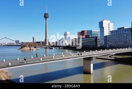 Düsseldorf, Deutschland. März 2020. firo: 24.03.2020, Deutschland, NRW, Düsseldorf, Drohnenfoto, Unternehmen, wenige Fußgänger im Medienhafen Düsseldorf, an der lebenden Brücke, Kontaktverbot, das Sammeln von mehr als zwei Personen ist aufgrund der Coronakrise verboten, Sperrung aufgrund von Corona, Corona-Virus, Kovid -19, Nutzung weltweit Credit: Dpa / Alamy Live News Stockfoto