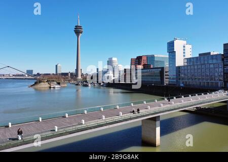 Düsseldorf, Deutschland. März 2020. firo: 24.03.2020, Deutschland, NRW, Düsseldorf, Drohnenfoto, Unternehmen, wenige Fußgänger im Medienhafen Düsseldorf, an der lebenden Brücke, Kontaktverbot, das Sammeln von mehr als zwei Personen ist aufgrund der Coronakrise verboten, Sperrung aufgrund von Corona, Corona-Virus, Kovid -19, Nutzung weltweit Credit: Dpa / Alamy Live News Stockfoto