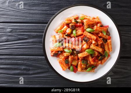 Tortiglioni Pasta Diät-Rezept mit Sommergemüse und in Tomatensauce in einer Platte auf dem Tisch backen. Horizontale Draufsicht von oben Stockfoto