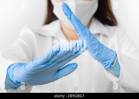 Stoppen Sie SARS-COV, SARSCoV, Virus 2020, MERS-COV, chinese Virus COVID-19. Close-Womans Hände in blauen medizinischen Handschuhen zeigen EIN STOPPZEICHEN für Krankheit. Arzt Stockfoto