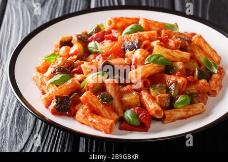 Tortiglioni Pasta Diät-Rezept mit Sommergemüse und in Tomatensauce in einer Platte auf dem Tisch backen. Horizontal Stockfoto