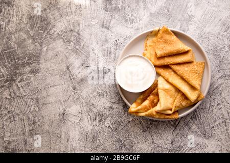 Traditionelle russische Pfannkuchen. Gebratene Crepes mit Sauerrahm/ Stockfoto