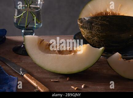 Melonenstück auf Holzhintergrund und Messer. Stockfoto