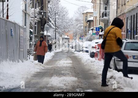 Die Menschen wandern in Schneeverwehungen auf unverputzter Straße, nach schneeblutten in Sofia, Bulgarien am 24. märz 2020 Stockfoto