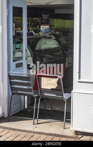 Sidmouth, Devon, 24. März 2020 zwei Stühle blockieren den "enbtrance" zu einem beliebten Ince-creme-Geschäft, das aufgrund des Ausbruchs des Coronavirus in Sidmouth, Devon geschlossen wurde. Credit: Photo Central/Alamy Live News Stockfoto