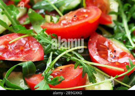 Salat mit Arugula, Tomaten, Gurken und Zitronensauce. Stockfoto