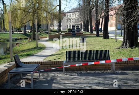 Luckenwalde, Deutschland. März 2020. Die Bänke im Nuthepark sind mit rotem und weißem Wegeband abgedrandet. Mit der Kennzeichnung will die Stadt das Verbot von Menschenmassen in Parks und öffentlichen Bereichen durchsetzen, das aufgrund der Corona-Pandemie erlassen wurde. Credit: Soeren Stache / dpa-Zentralbild / dpa / Alamy Live News Stockfoto