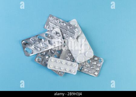 Ein Stapel verwendete Blisterpackungen mit Pillen auf blauem Hintergrund. Medizinische Blisterpackungen geöffnet und leer ohne Pillen Draufsicht. Medizinisches und medizinisches Konzept. Stockfoto