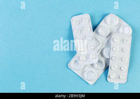 Ein Stapel verwendete Blisterpackungen mit Pillen auf blauem Hintergrund. Medizinische Blisterpackungen geöffnet und leer ohne Pillen Draufsicht. Medizinisches und medizinisches Konzept. Stockfoto