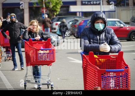 Coronavirus pandemic Effects: Lange Schlange, um den Supermarkt für Lebensmittelgeschäfte zu betreten. Turin, Italien - März 2020 Stockfoto