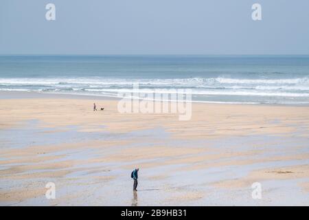 Newquay, Cornwall, Großbritannien. März 2020. Die Anwohner, die die Regierung beraten und sicherstellen, dass zwischen ihnen 2 Meter Abstand ist, da sie einen menschenleeren Fistral Beach in Newquay in Cornwall genießen. Gordon Scammell/Alamy Live News. Stockfoto