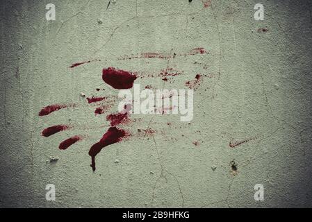 Rotes Blut wie eine Handform, die auf dem Grunge Wandhintergrund im verlassenen Haus festsaß. Halloween verfolgt Szene und spoky Konzept. Stockfoto