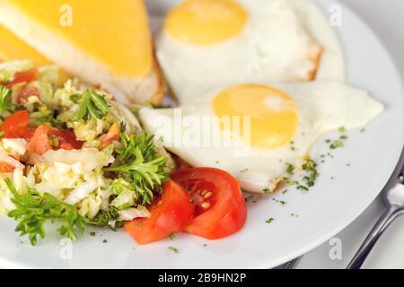 Leckeres Frühstück. Spiegeleier mit Salat und Toast. Geringe Schärfentiefe Stockfoto