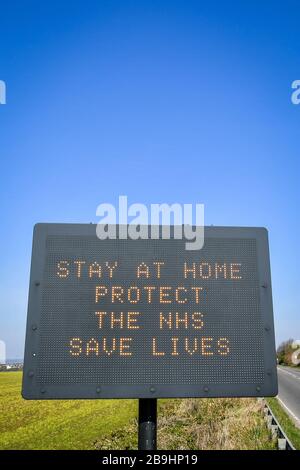 Ein Schild auf der A367 in Bath empfiehlt Autofahrern, zu Hause zu bleiben, um die NHS zu schützen und am Tag nach der Versperrung durch Premierminister Boris Johnson Leben zu retten, um die Ausbreitung des Coronavirus einzudämmen. Stockfoto