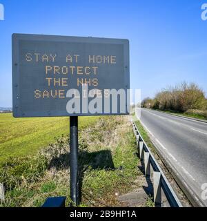 Ein Schild auf der A367 in Bath empfiehlt Autofahrern, zu Hause zu bleiben, um die NHS zu schützen und am Tag nach der Versperrung durch Premierminister Boris Johnson Leben zu retten, um die Ausbreitung des Coronavirus einzudämmen. Stockfoto