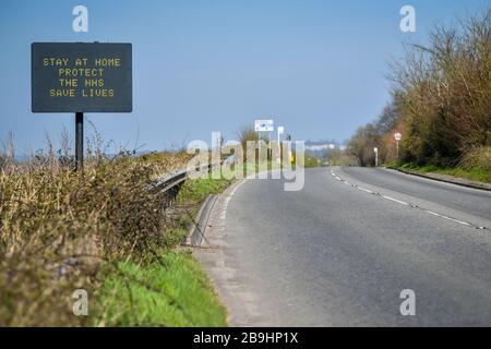 Ein Schild auf der A367 in Bath empfiehlt Autofahrern, zu Hause zu bleiben, um die NHS zu schützen und am Tag nach der Versperrung durch Premierminister Boris Johnson Leben zu retten, um die Ausbreitung des Coronavirus einzudämmen. Stockfoto