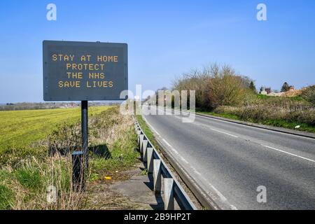 Ein Schild auf der A367 in Bath empfiehlt Autofahrern, zu Hause zu bleiben, um die NHS zu schützen und am Tag nach der Versperrung durch Premierminister Boris Johnson Leben zu retten, um die Ausbreitung des Coronavirus einzudämmen. Stockfoto